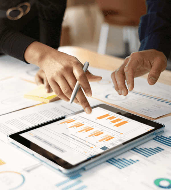 People reviewing charts and financial analysis on a tablet, representingcost optimization in card payment processing