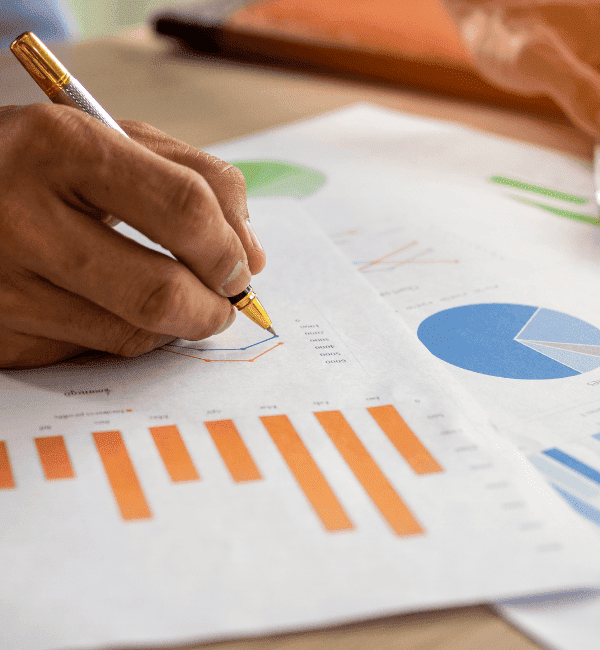 Person reviewing financial charts and graphs with a calculator, focused onoptimizing card brand agreements