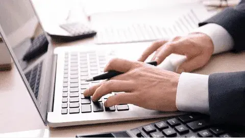 Person analyzing financial data on a laptop for card brand agreementoptimization.
