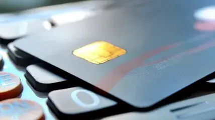 Cardholder making a contactless payment via POS terminal, illustrating debit and credit card processing optimization
